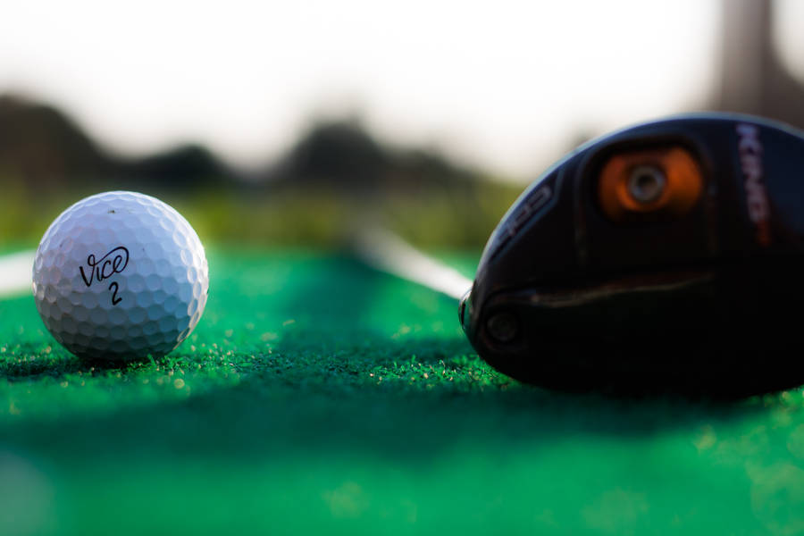 Golf Ball And Club Lying On Golf Course Wallpaper