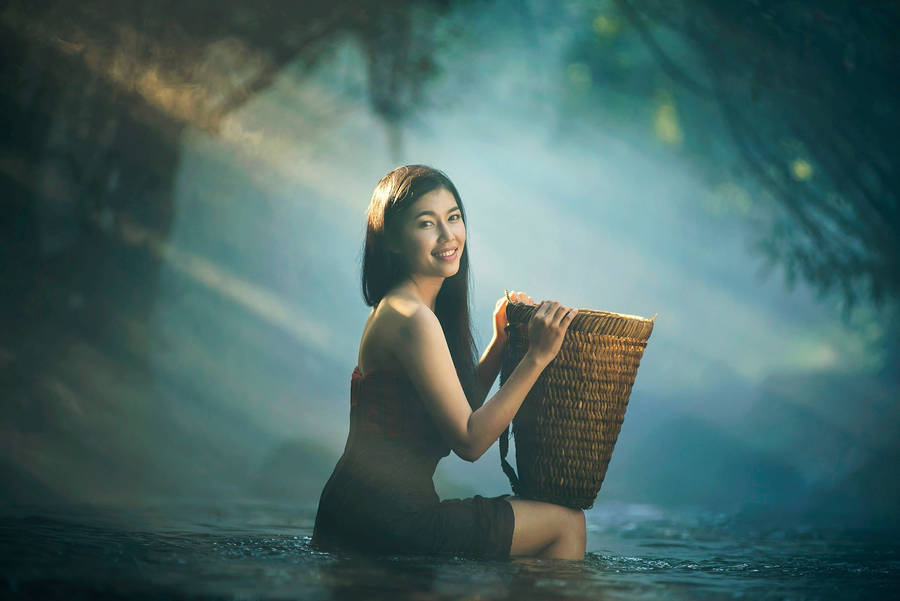 Graceful Asian Woman Carrying Traditional Rattan Basket Wallpaper