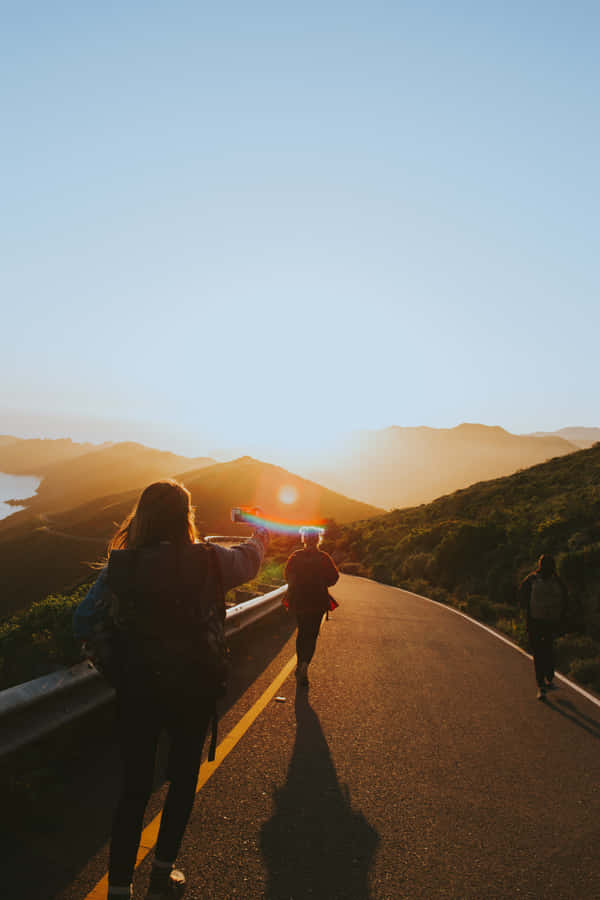 Group Of Friends Walking Along The Highway Wallpaper