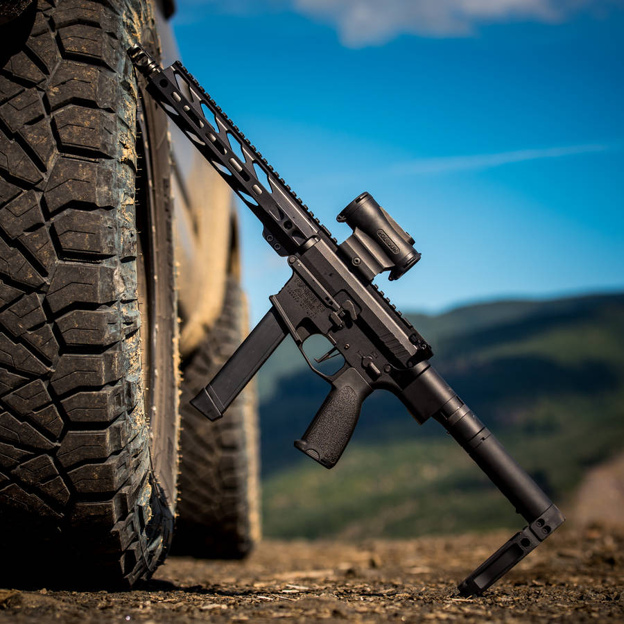 Gun Leaning On Tire Wallpaper