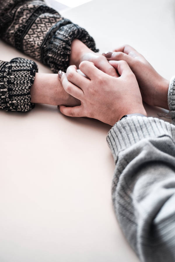 Hand In Hand On White Table Wallpaper