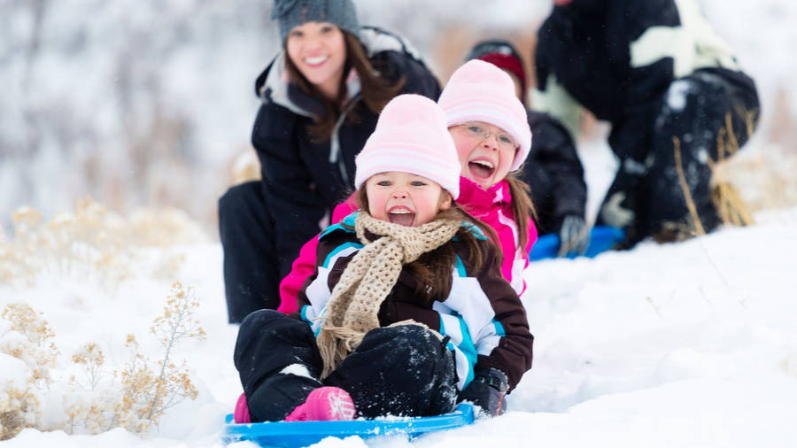 Happy Family Winter Sledding Wallpaper