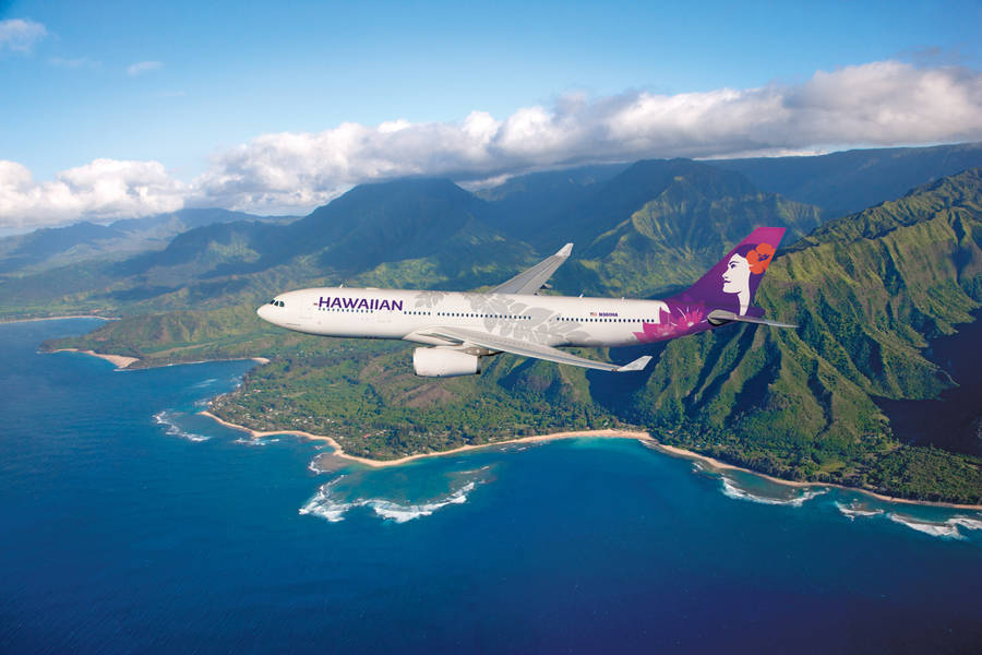 Hawaiian Airlines Plane Over Lush Green Mountains Wallpaper