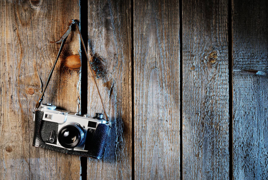 Hd Camera On Wooden Plank Wall Wallpaper