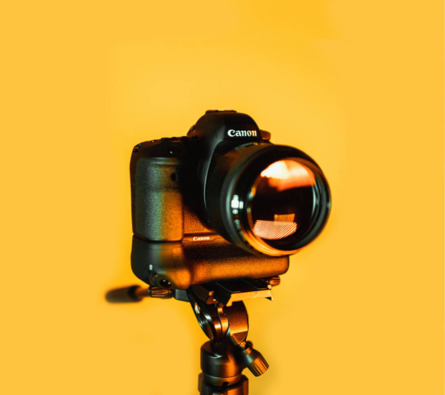 Hd Photography Of A Camera On Yellow Backdrop Wallpaper