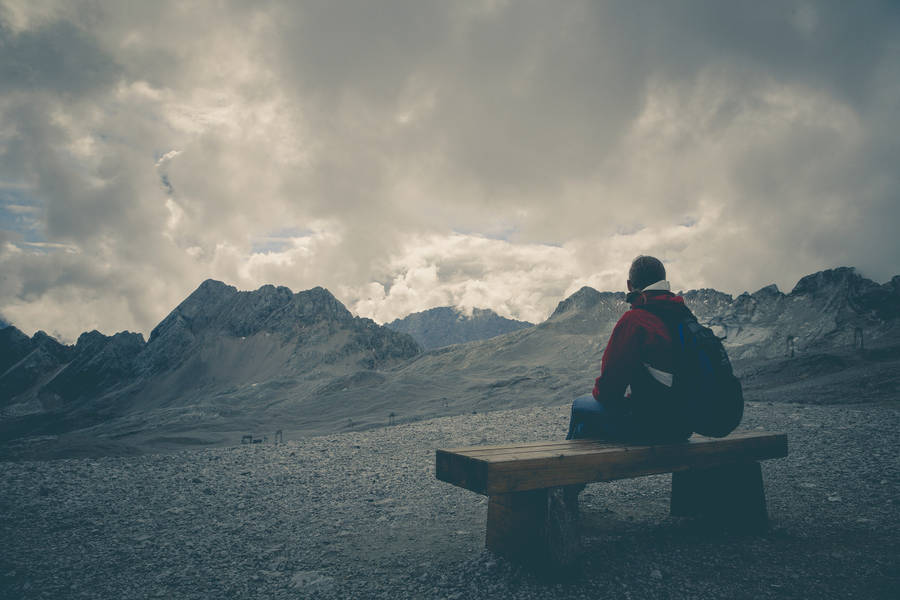 Hiker Sitting Alone On Flat Bench Wallpaper