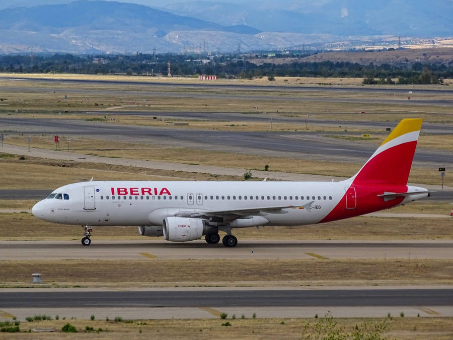 Iberia Airlines Airplane On Rural Runway Wallpaper