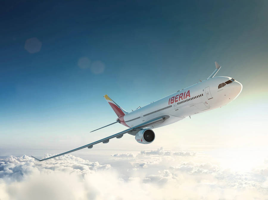 Iberia Airplane Gliding Sideways Above Clouds Wallpaper