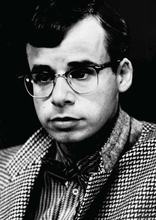 Iconic Actor Rick Moranis Sitting At A Cafe Wallpaper