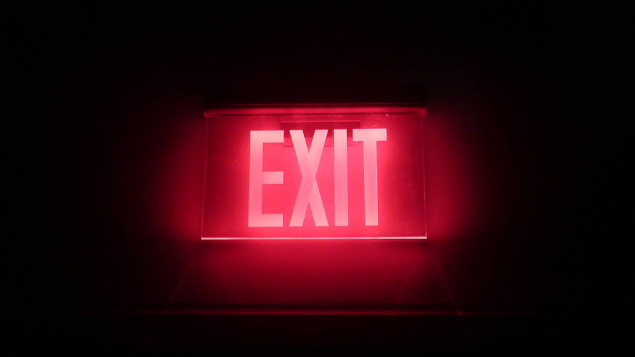 Illuminated Exit Sign Displayed On Black Tablet Screen Wallpaper