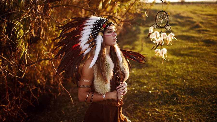 Indigenous Woman In Cultural Feathered Costume Wallpaper