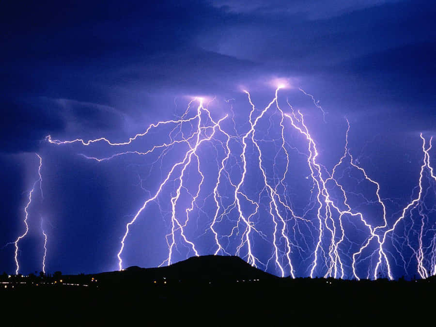 Intense Blue Lightning Stretches Across The Evening Sky Wallpaper