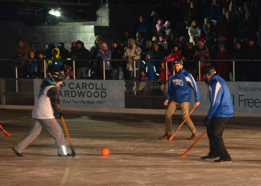 Intense Broomball Match With Blue And White Teams Wallpaper