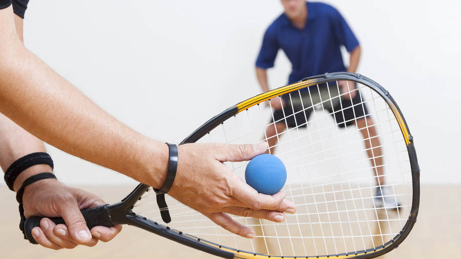 Intense Racquetball Match Between Two Strong Men Wallpaper