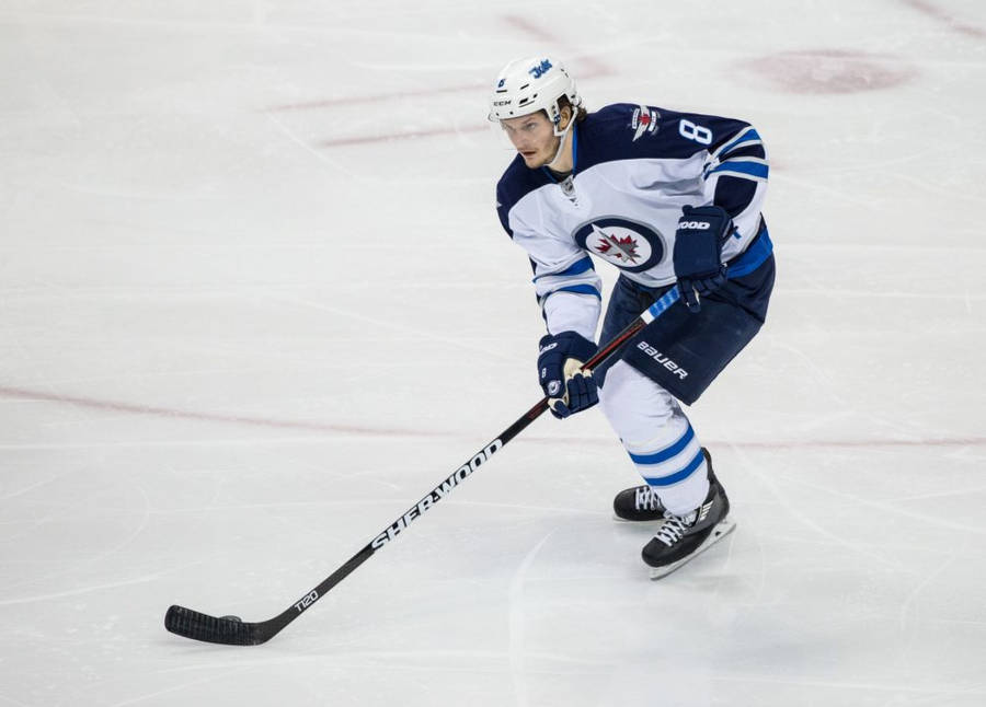 Jacob Trouba Leaning To The Left While Holding Hockey Stick Wallpaper