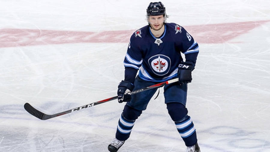 Jacob Trouba Raising His Hockey Stick During A Game Wallpaper