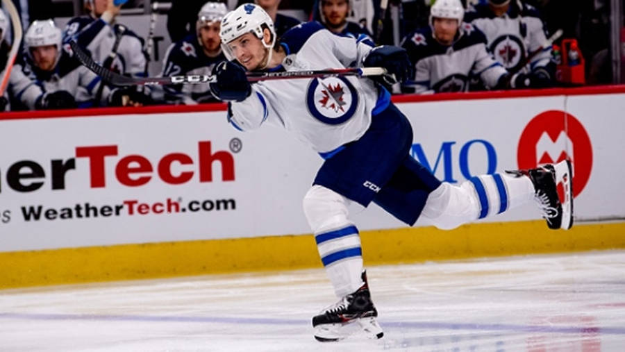 Jacob Trouba Swinging Hockey Stick With Right Leg Raised At The Back Wallpaper