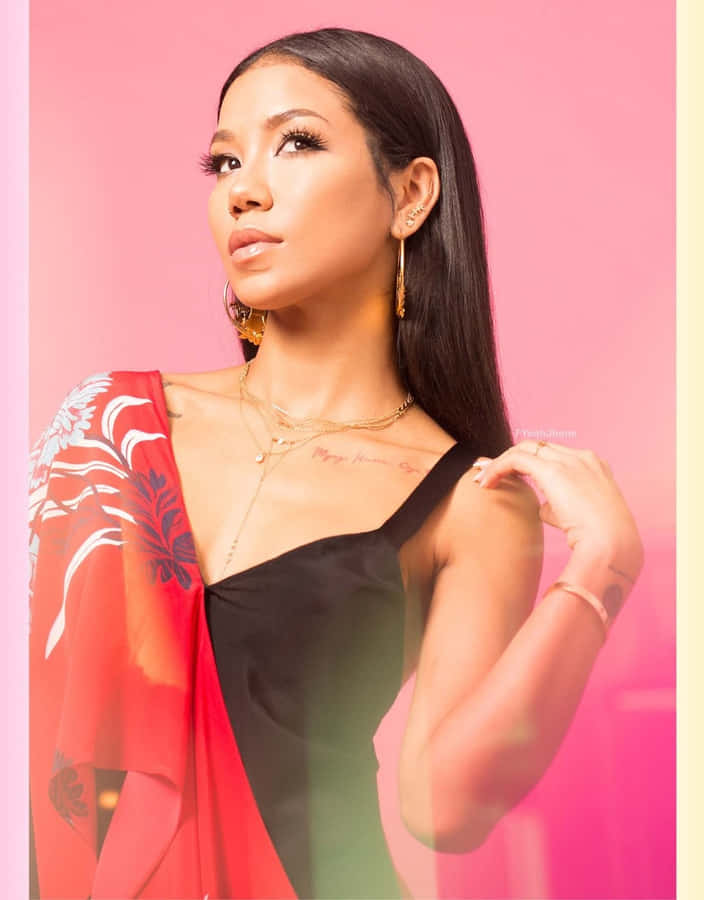 Jhene Aiko Striking A Pose Against A Vibrant Backdrop Wallpaper