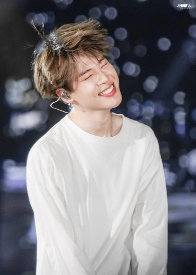 Jimin Of Bts Smiles At His Fans Onstage Wallpaper