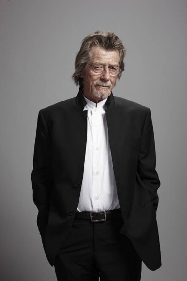 John Hurt Gray Background In Black Coat Wallpaper