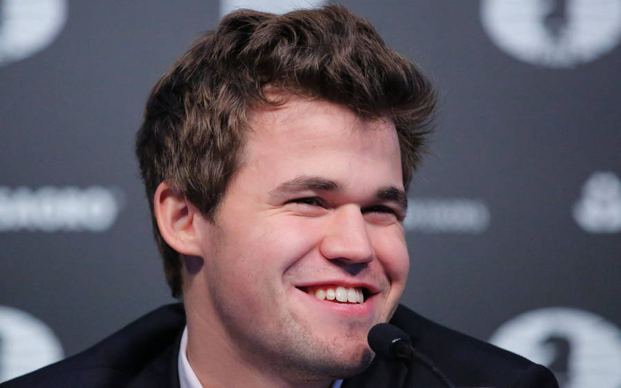 Joyful Magnus Carlsen Celebrating His Winning Move Wallpaper