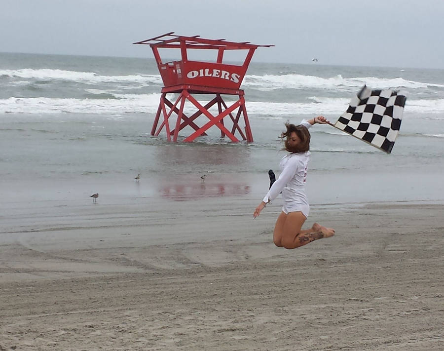 Jumping Girl Holding Checkered Flag Wallpaper