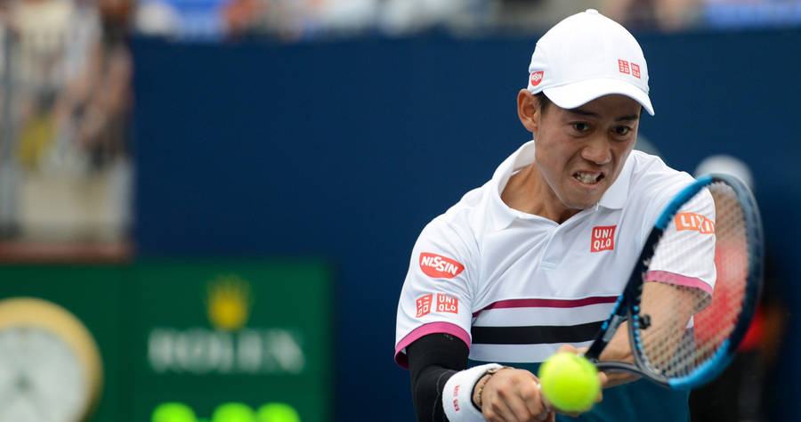 Kei Nishikori Executes A Power-packed Two-handed Stroke During A Grand Slam Wallpaper