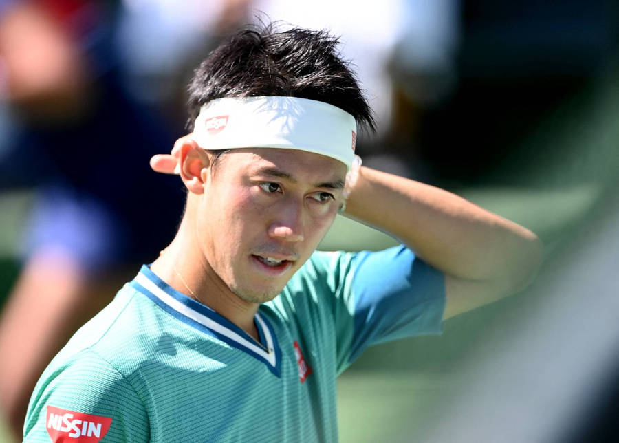 Kei Nishikori Pondering Strategy On The Tennis Court Wallpaper