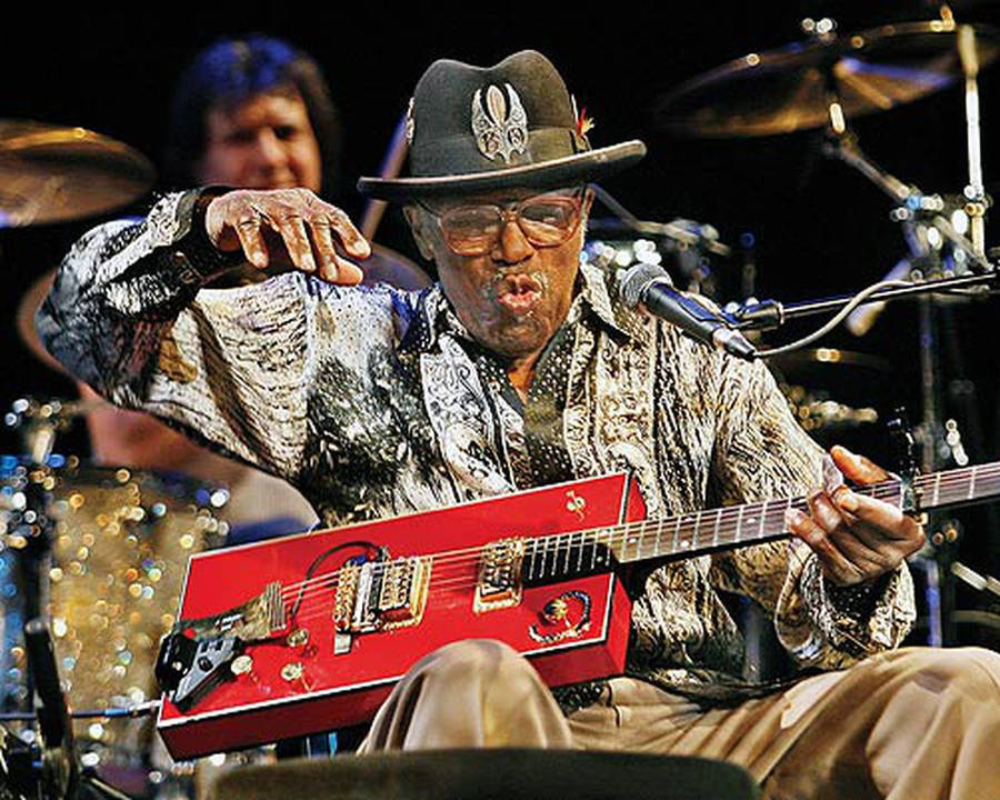 Legendary Musician Bo Diddley Showcasing His Unique Guitar Skills Wallpaper