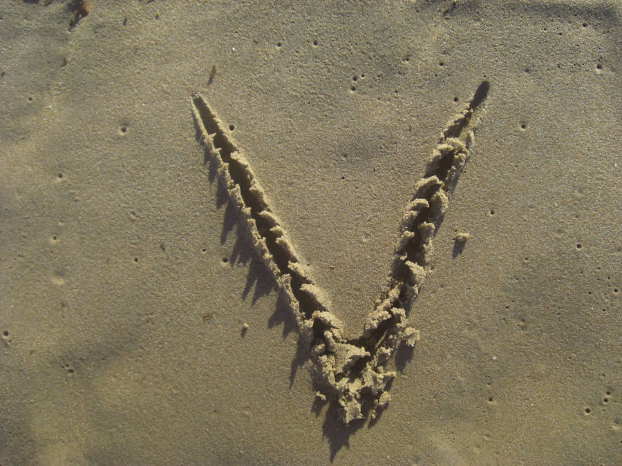 Letter V Drawn On Sand Wallpaper