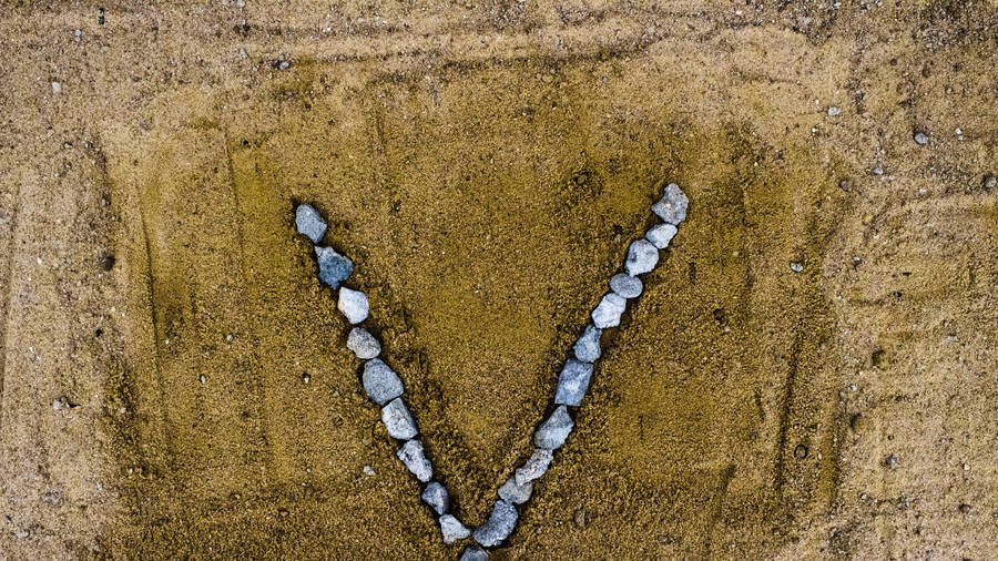 Letter V Shaped Rocks On Sand Wallpaper