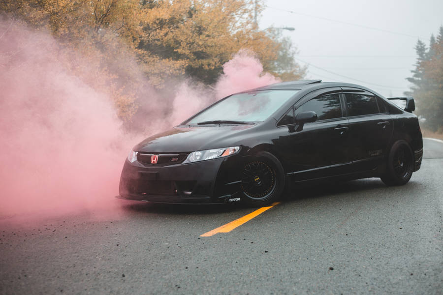 Majestic Black Sports Car Amidst Pink Smoke Wallpaper