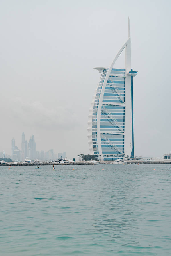 Majestic Burj Al Arab Against A Refreshing Pastel Blue Sky Wallpaper