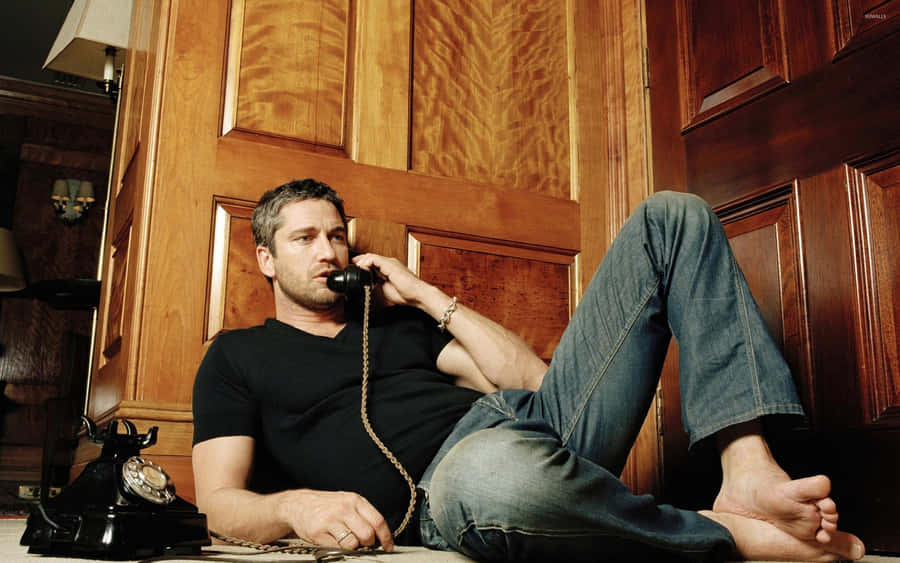 Male Actor Gerard Butler Calling In Bare Feet Wallpaper