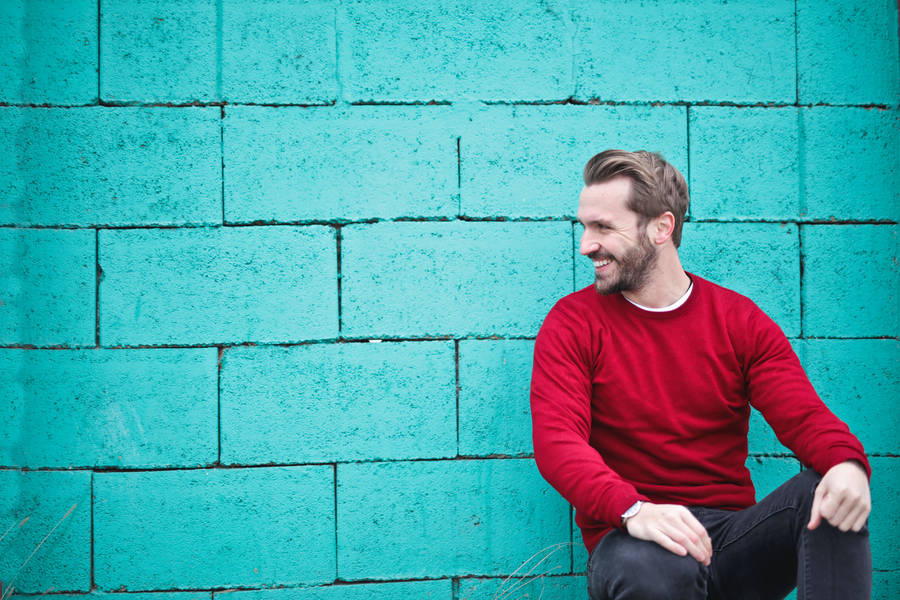 Male Pose Against Blue Brick Wall Wallpaper