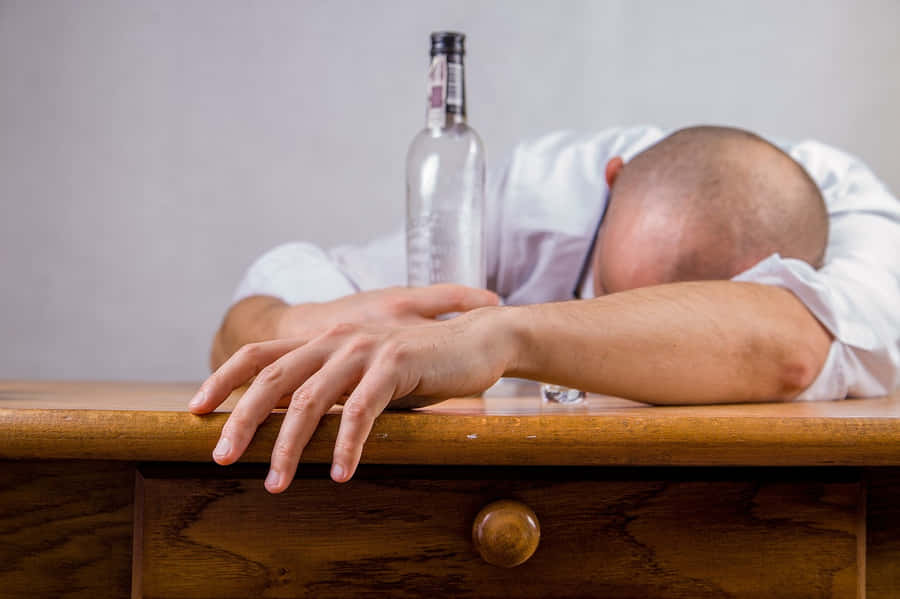 Man Asleep Desk Alcohol Bottle Wallpaper