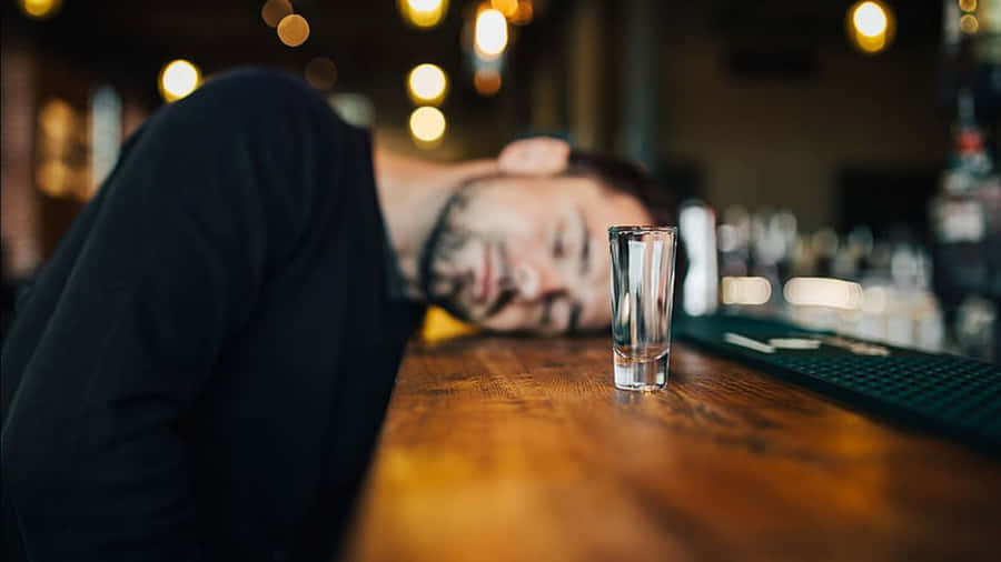 Man Asleepat Barwith Empty Glass Wallpaper