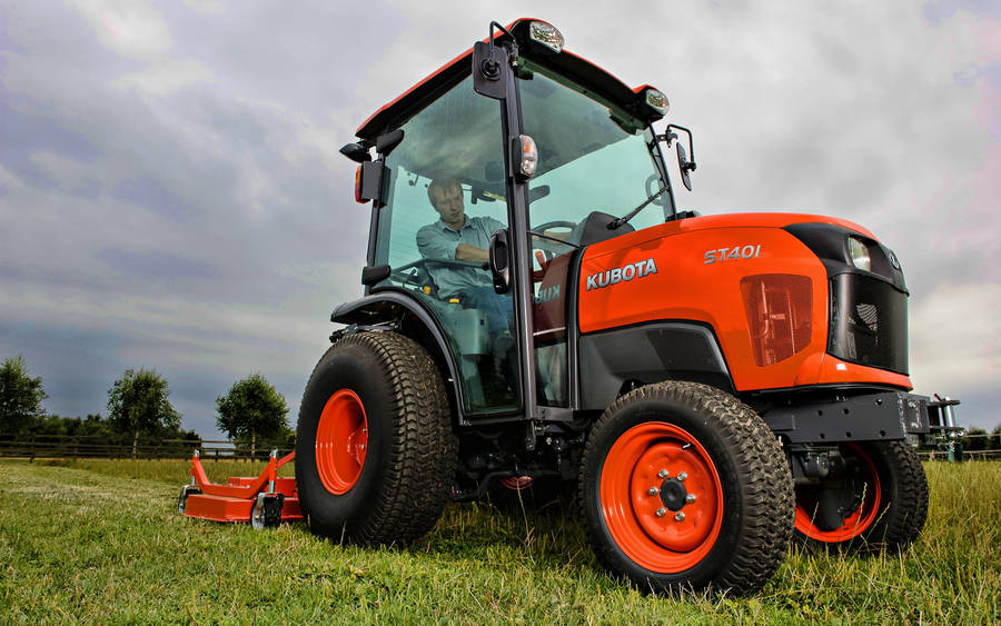 Man Driving Orange Kubota Tractor Wallpaper