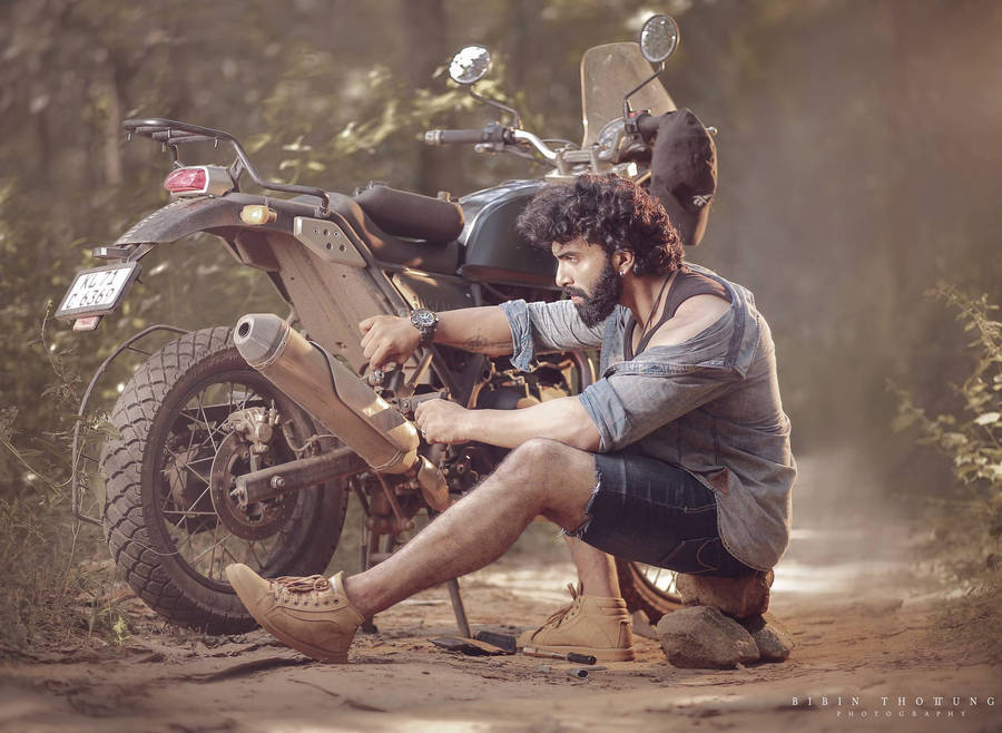 Man Fixing Himalayan Bike Wallpaper