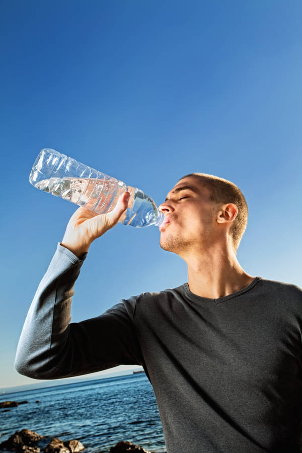 Man Hydrating With Bottled Water Wallpaper