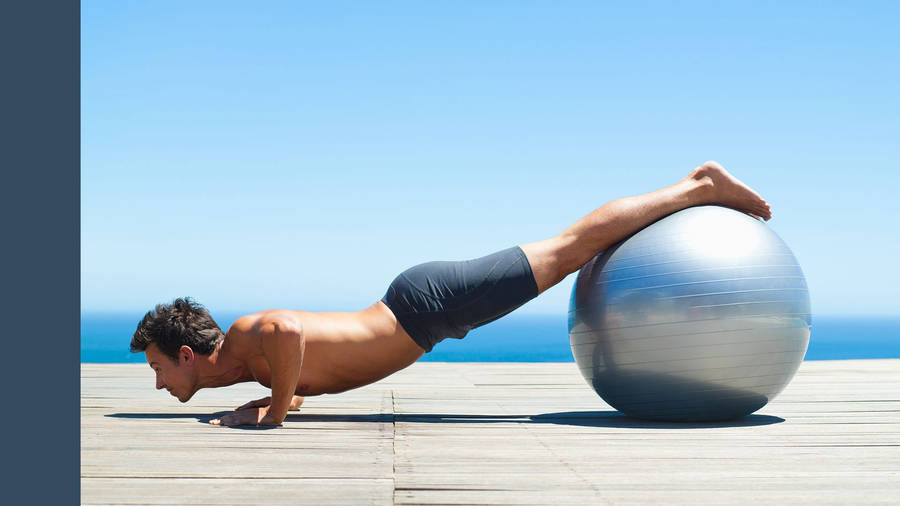 Man In Pilates With Metallic Ball Wallpaper