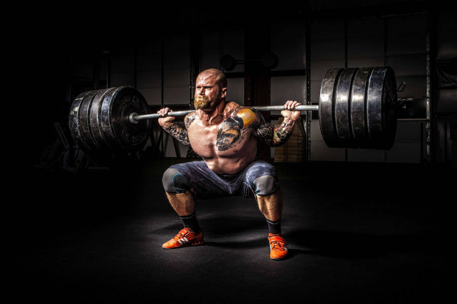 Man Lifting 4 Plates Barbell Wallpaper