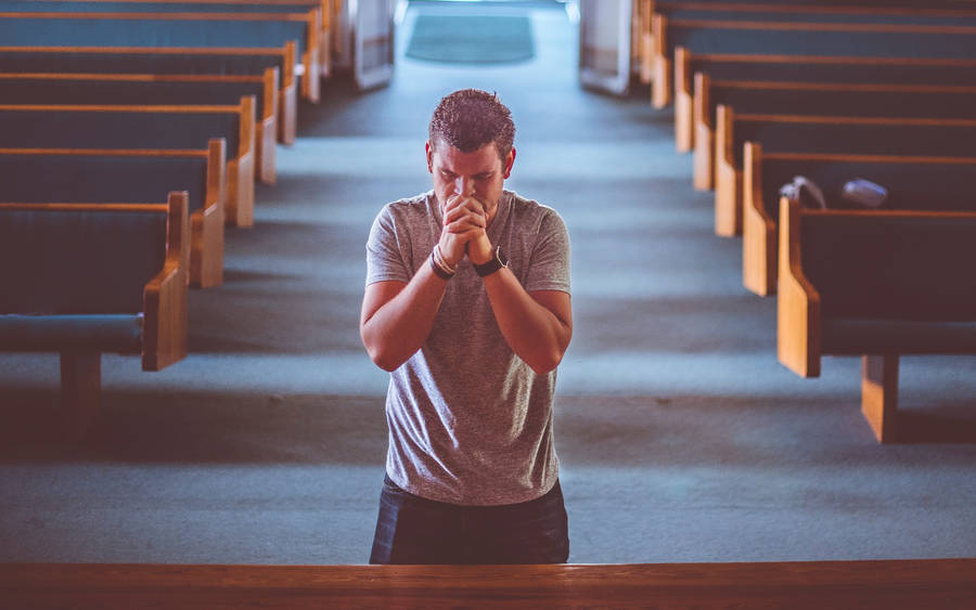 Man Praying Alone In Church Wallpaper