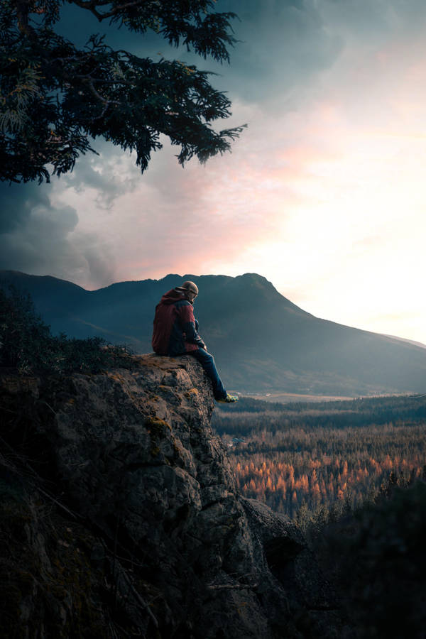 Man Sitting On Rock Alone Phone Wallpaper