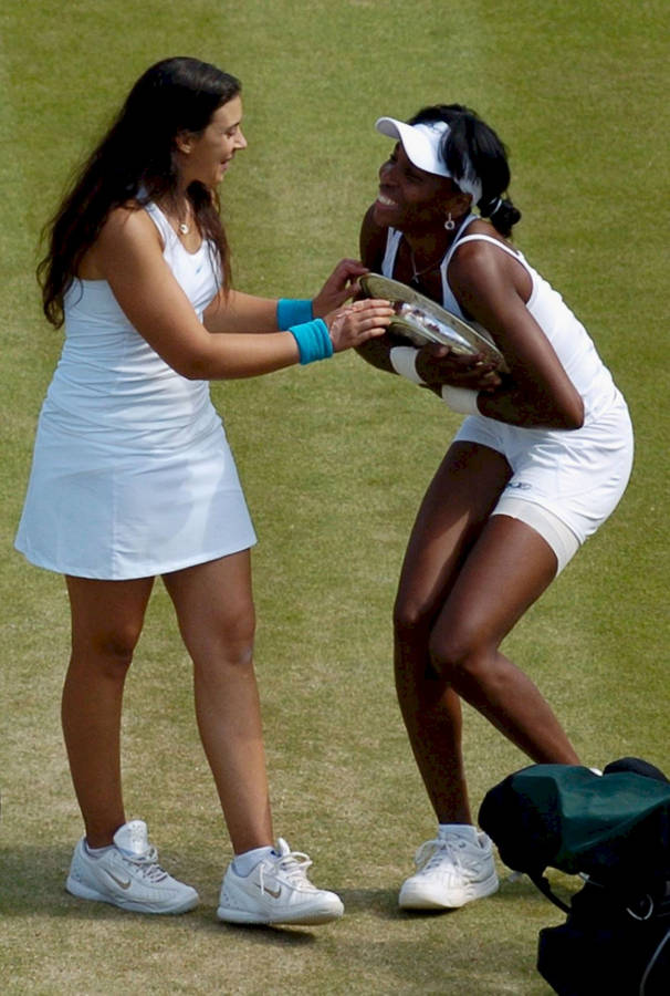 Marion Bartoli And Venus Williams During A Tennis Match. Wallpaper