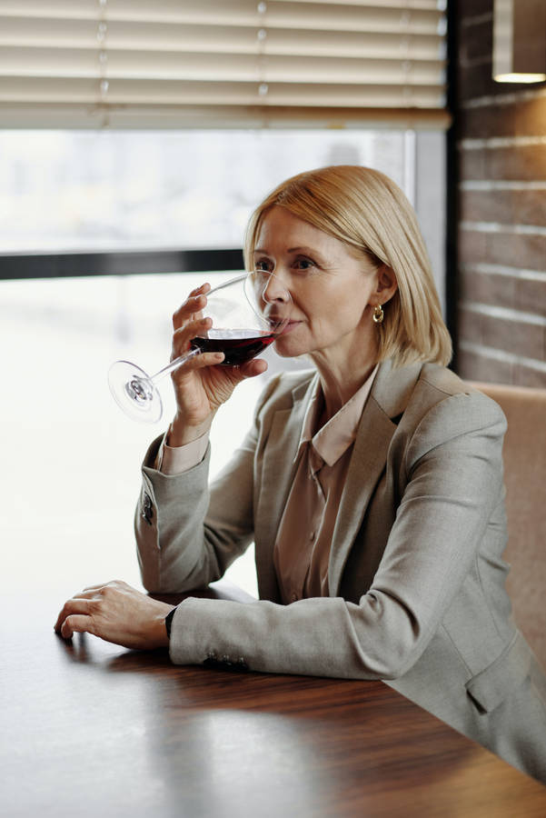 Mature Woman Sipping Wine Wallpaper