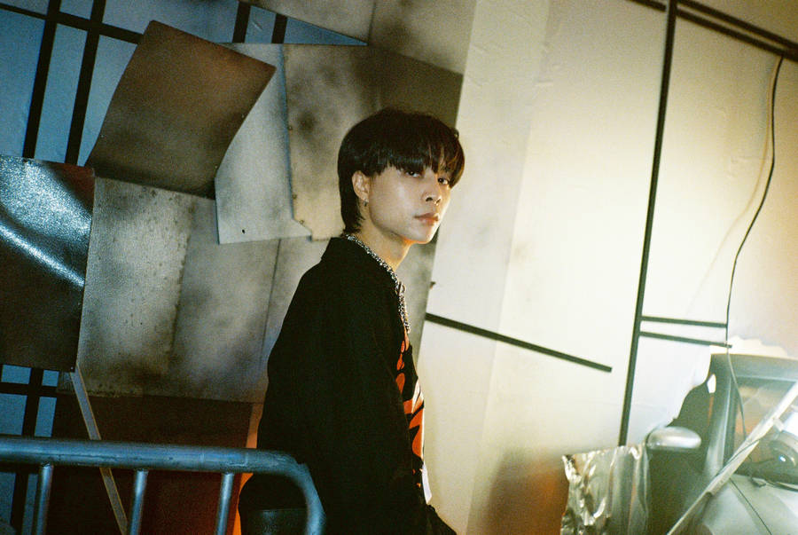 Member Of Nct 127, Johnny, Captured In A Vivid Portrayal Against An Earthquake Image Backdrop. Wallpaper