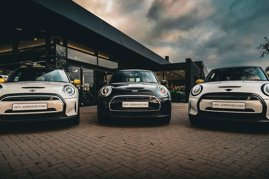 Mini Black And White Cars Outside Building Wallpaper