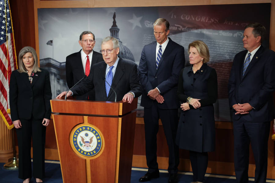 Mitch Mcconnell Critiquing Policies During A News Conference Wallpaper