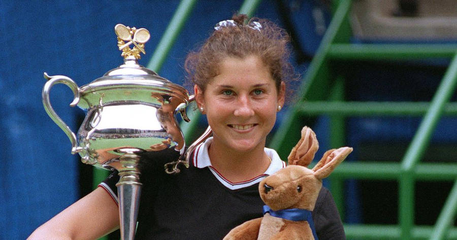 Monica Seles Holding Trophy And Toy Wallpaper